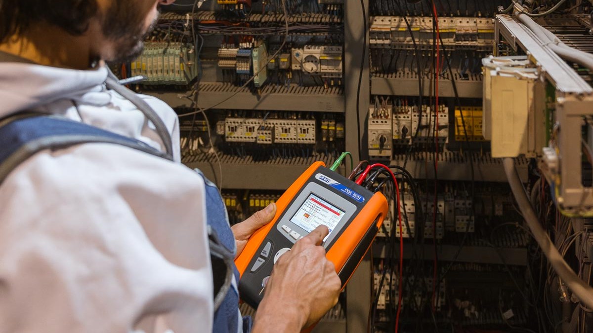 Técnico con casco amarillo realizando medición de calidad de energía con un analizador HT PQA 824 en un tablero eléctrico